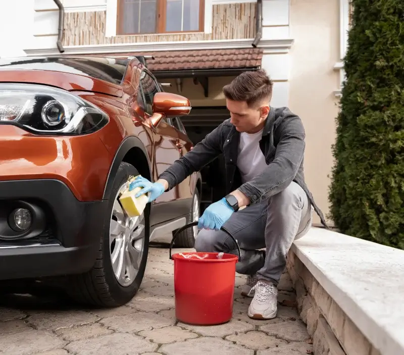 Lavage auto à domicile Dun-le-Poëlier : professionnel intervenant sur un véhicule